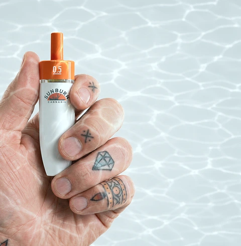 A Buoy device held in a tattooed hand
